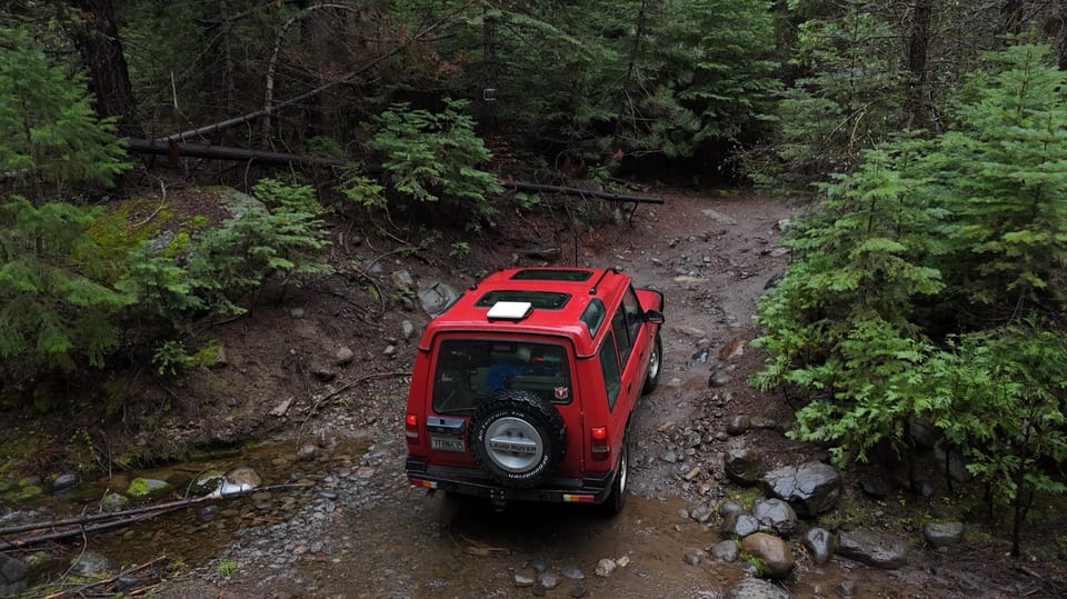 Starlink Mini mounted on an off-road vehicle trail in a mountain forest
